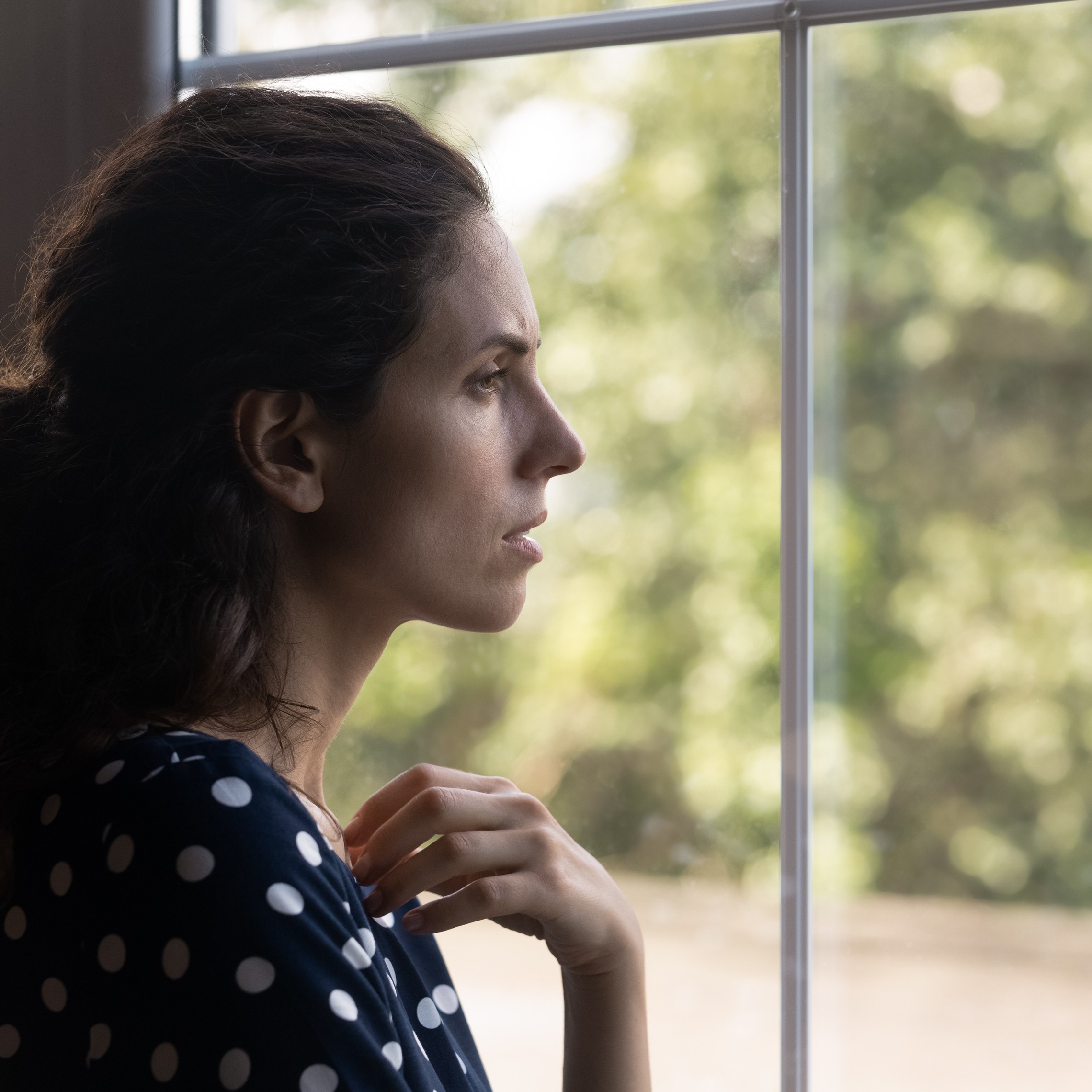 A neighbor in need looks out of the window with concern